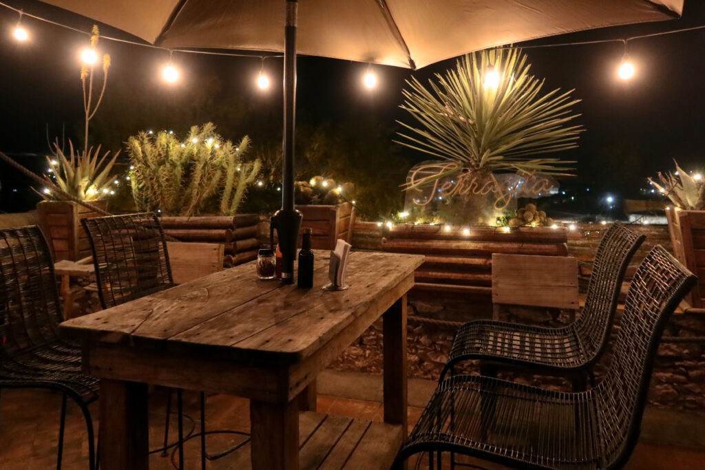 A Rustic restaurant table in Mexican town, with lights at night